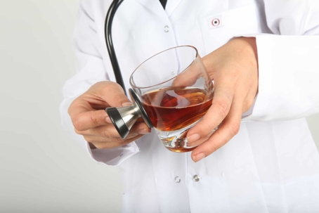 Doctor with glass of alcohol