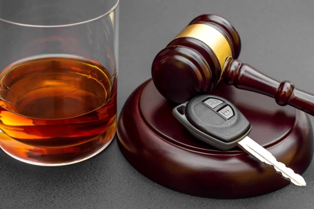 Gavel, keys, and glass of alcohol